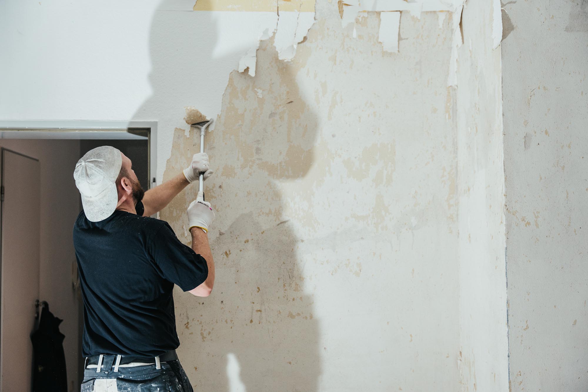 Mann entfernt eine Tapete